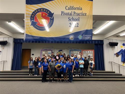 Ms. Arroyo-Mendo posing with her 6th grade class